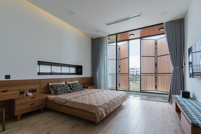 Phòng ngủ và phòng sách được thiết kế ở 2 tầng kế tiếp của ngôi nhà vẫn được nhận đầy đủ lượng ánh sáng tự nhiên nhờ giếng trời làm bằng kính và bề mặt gỗ trên sân thượng.